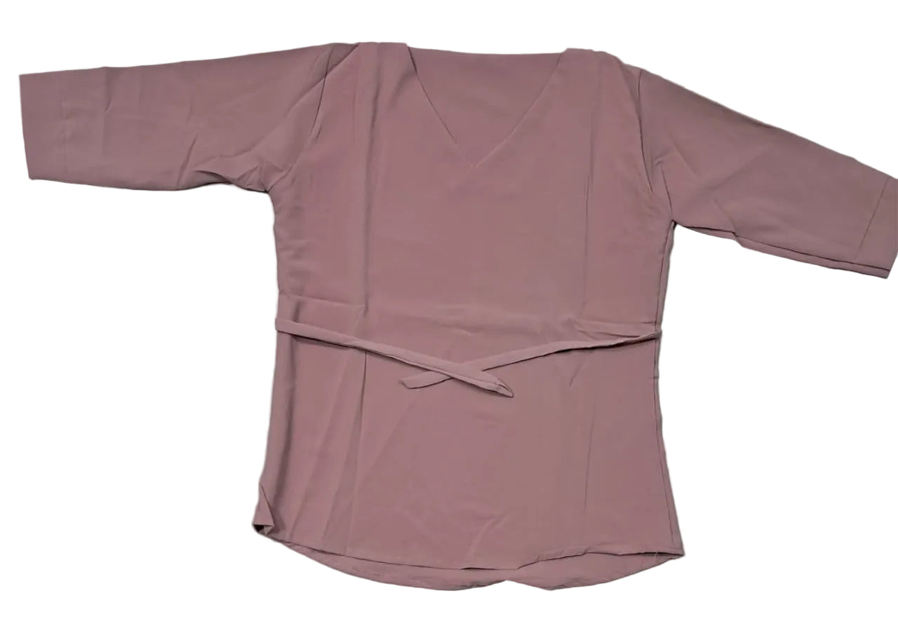 Pink long-sleeve top on a light gray surface